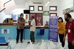 bro. Heri is giving a packet of food to the people in need...